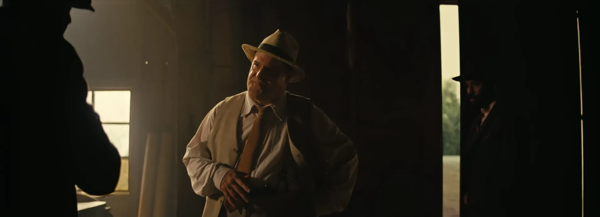 White mill buyer in fedora, doorway.